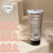 Abbildung der Rückseite der Bali Curls Deep Hydration Mask auf beigen Steintreppenstufen mit einem: "0% Parabens, Sulfates and Silicones" Sticker in der linken oberen Ecke
