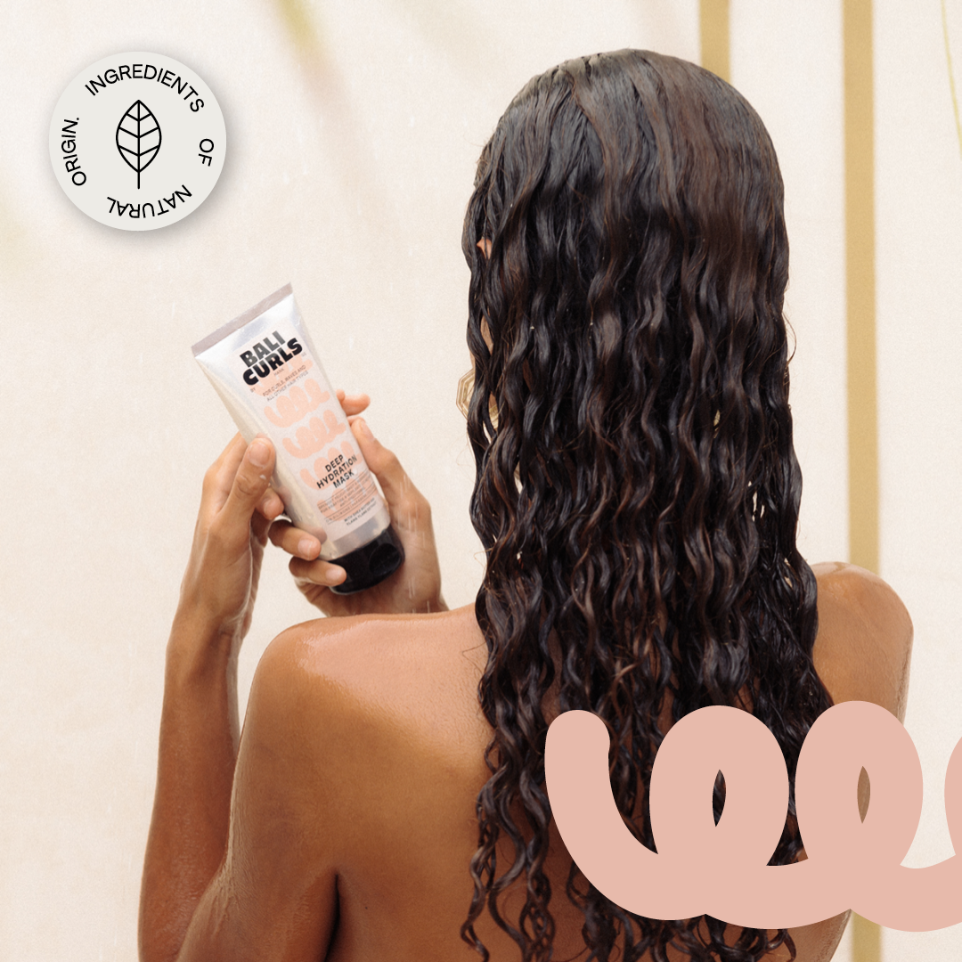 Abbildung des Hinterkopfes einer Frau mit schönen lockigen Haaren, der Bali Curls deep Hydration Mask in der Hand und einem: " Ingredients of Natural Origin." Sticker in der linken oberen Ecke