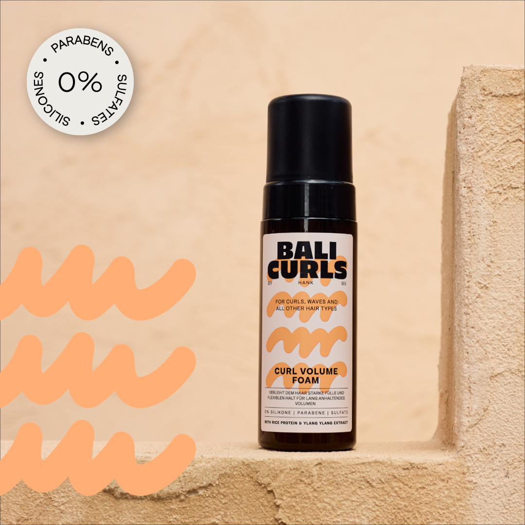 Abbildung des Bali Curls Curl Volume Foam auf beigen Treppenstufen mit einem: "0% Parabens, Sulfates und Silicones" in der linken oberen Ecke