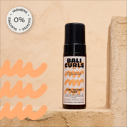Abbildung des Bali Curls Curl Volume Foam auf beigen Treppenstufen mit einem: "0% Parabens, Sulfates und Silicones" in der linken oberen Ecke