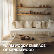 Abbildung eines Weißen Sofas mit Holztisch, neben einem weißen Vorhang, mit rustikaler, beiger Wand, einem Wandregal mit verschiedenen Wasen und der Unterschrift: "Warm Woody Embrace of Sandalwood"